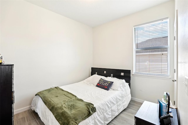 bedroom featuring baseboards and wood finished floors