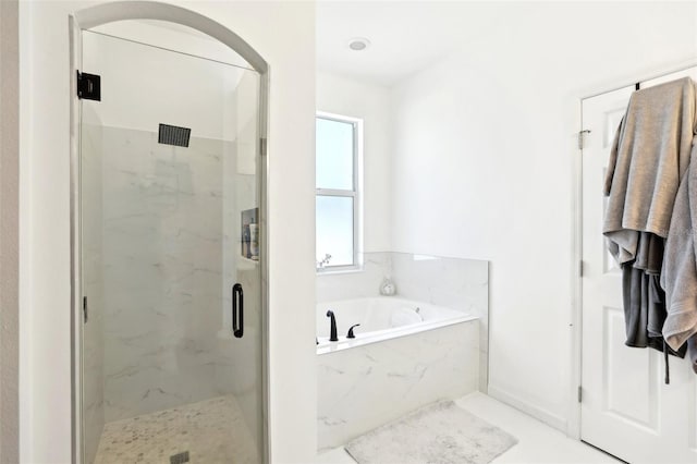 full bathroom featuring a marble finish shower and a garden tub