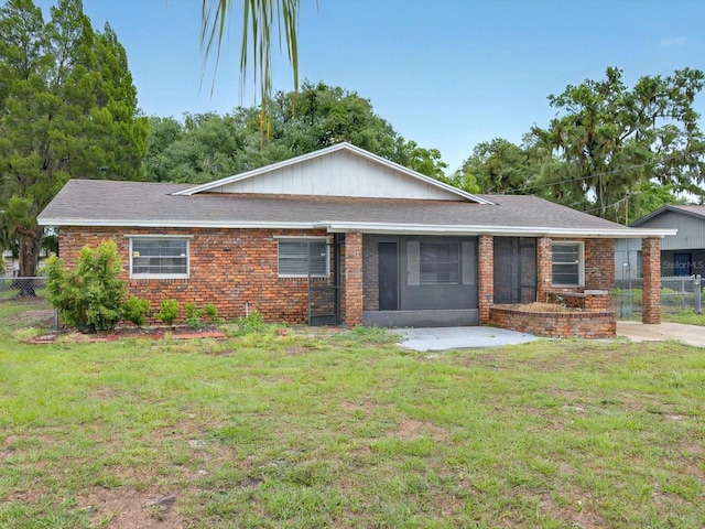 view of front of house featuring roof with shingles, brick siding, and a patio