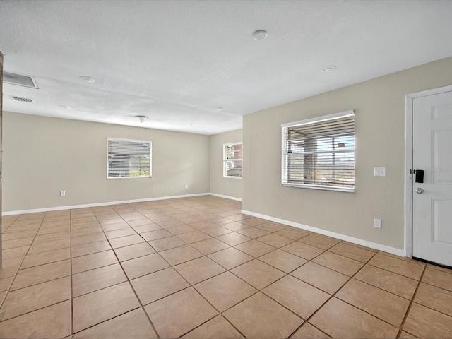 empty room featuring light tile patterned floors and baseboards