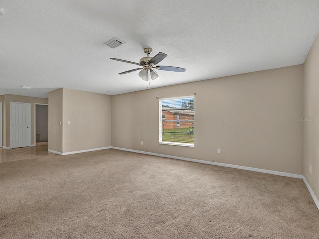 spare room featuring light carpet, ceiling fan, baseboards, and a textured ceiling