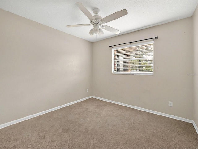 carpeted empty room with ceiling fan and baseboards