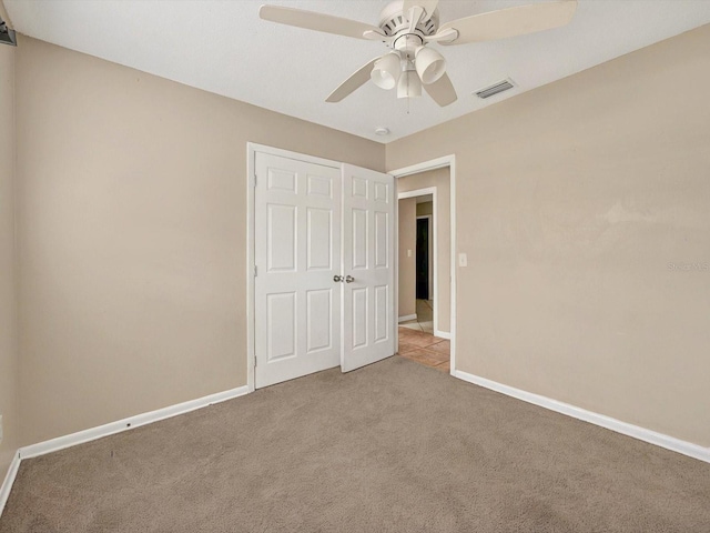unfurnished bedroom with carpet flooring, baseboards, and ceiling fan