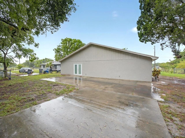 view of home's exterior featuring french doors, a patio, and fence
