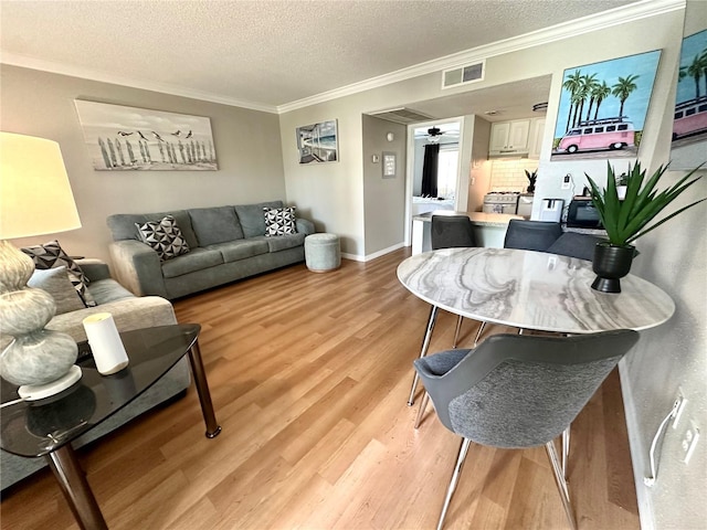 109 Oyster Bay Cir Unit 120, Altamonte Springs, FL 32701 - living area featuring ornamental molding, a textured ceiling, light wood-type flooring, and baseboards