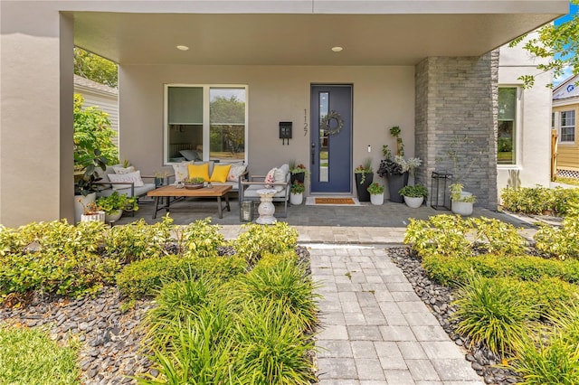 entrance to property with an outdoor living space and stucco siding
