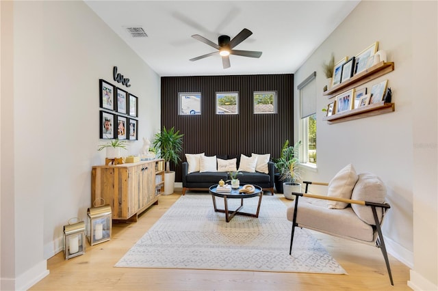 living area with ceiling fan, baseboards, visible vents, and wood finished floors