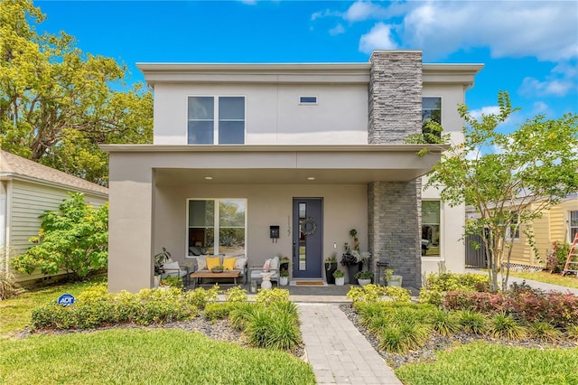contemporary home featuring covered porch and stucco siding