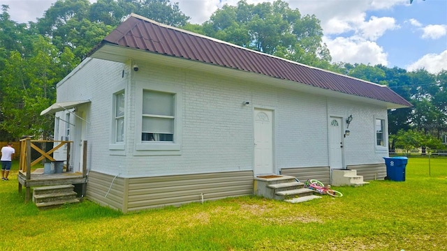412 Bay St NW, Fort Meade, FL 33841 - rear view of property featuring entry steps, brick siding, and metal roof