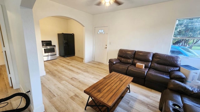 412 Bay St NW, Fort Meade, FL 33841 - living room featuring arched walkways, ceiling fan, and light wood finished floors