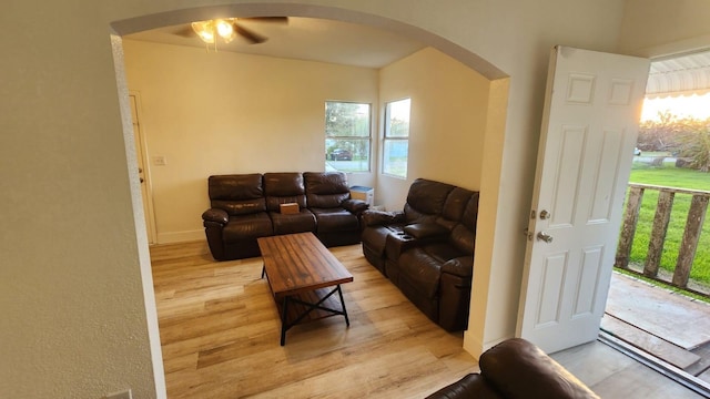 412 Bay St NW, Fort Meade, FL 33841 - living room featuring arched walkways, light wood-style floors, a ceiling fan, and baseboards