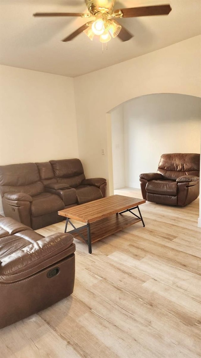 412 Bay St NW, Fort Meade, FL 33841 - living room featuring light wood-style floors, ceiling fan, and arched walkways