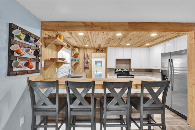 kitchen featuring a sink, recessed lighting, white cabinetry, wood ceiling, and appliances with stainless steel finishes