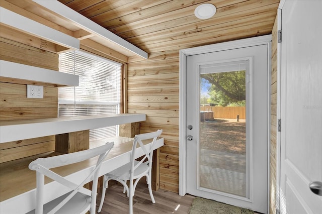 dining area with wooden ceiling, wooden walls, and wood finished floors