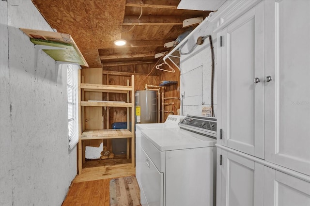 clothes washing area featuring light wood-style flooring, washer / dryer, cabinet space, and electric water heater