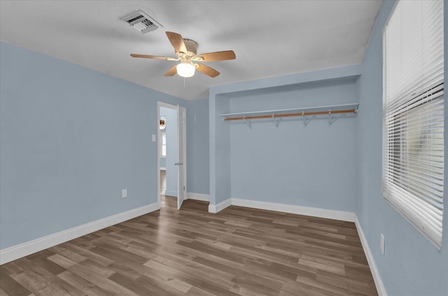 unfurnished bedroom featuring baseboards, a closet, visible vents, and wood finished floors