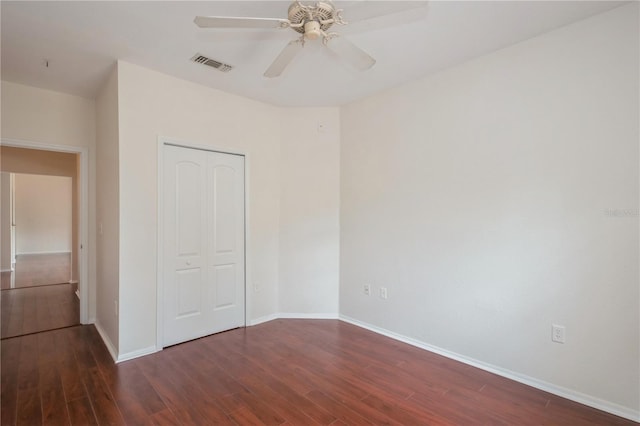 unfurnished bedroom with baseboards, a closet, visible vents, and wood finished floors
