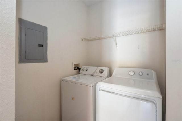 clothes washing area featuring laundry area, electric panel, and washer and clothes dryer
