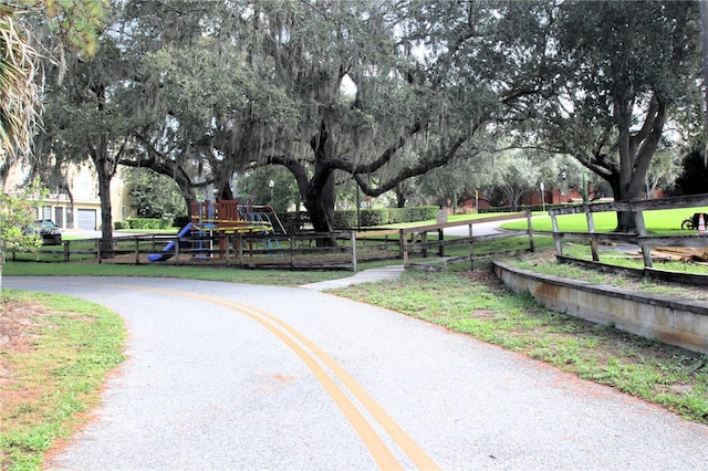view of property's community with playground community and fence