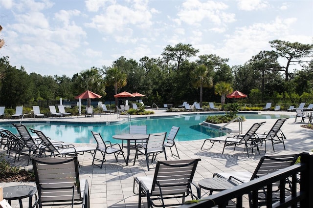 32618 Rapids Loop, Wesley Chapel, FL 33545 - community pool featuring fence, a patio area, and view of scattered trees