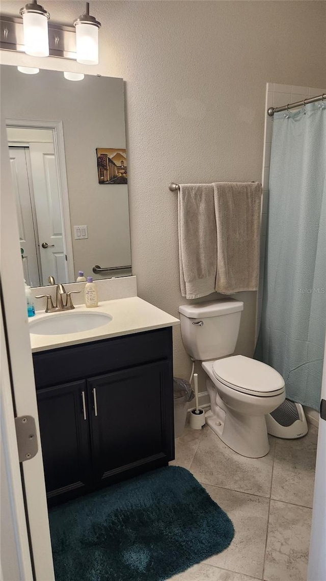 bathroom with toilet, tile patterned floors, vanity, and a shower with shower curtain
