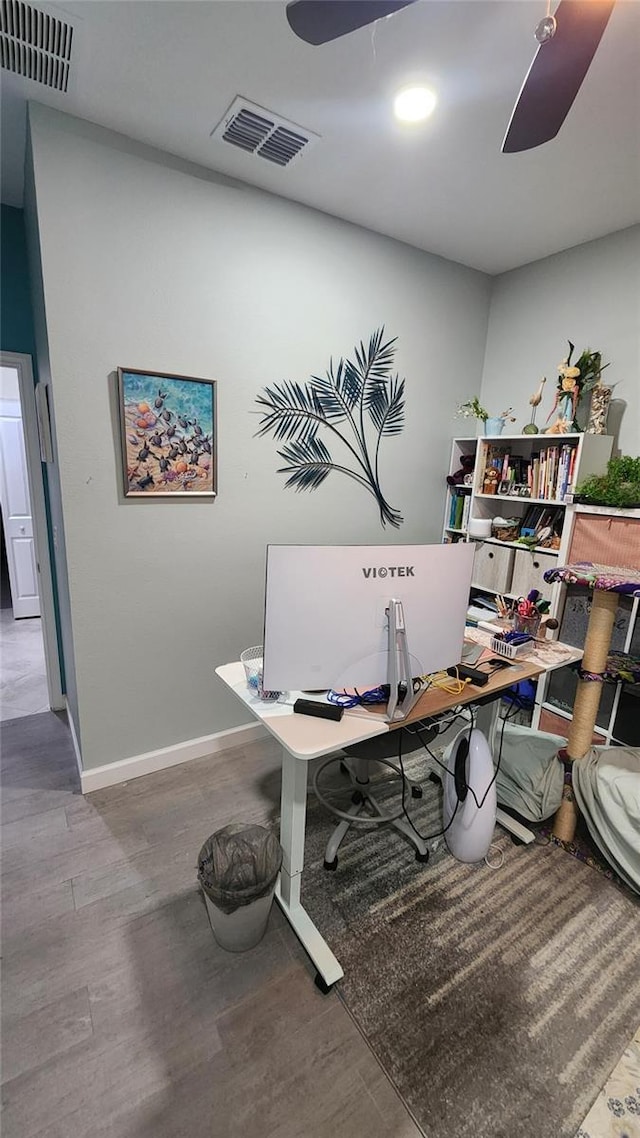 office space featuring baseboards, visible vents, wood finished floors, and a ceiling fan