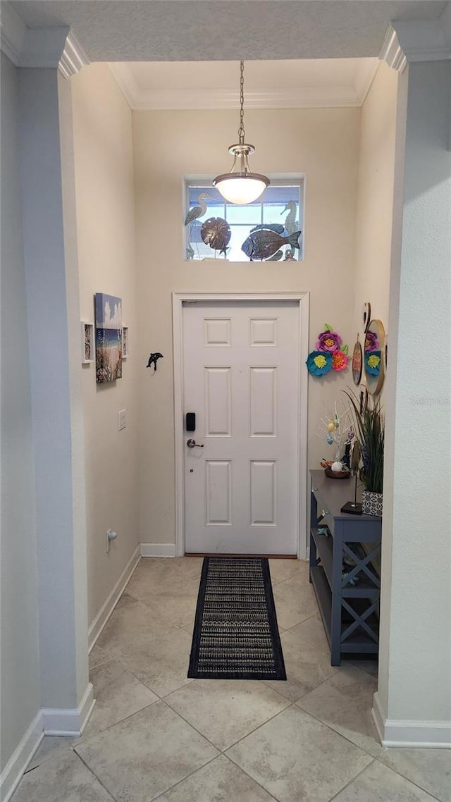 entryway with ornamental molding, baseboards, and light tile patterned floors