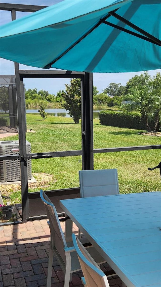 sunroom featuring a water view and outdoor dining area