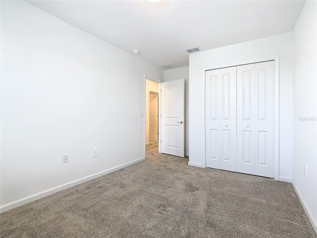 unfurnished bedroom with baseboards, carpet floors, and a closet