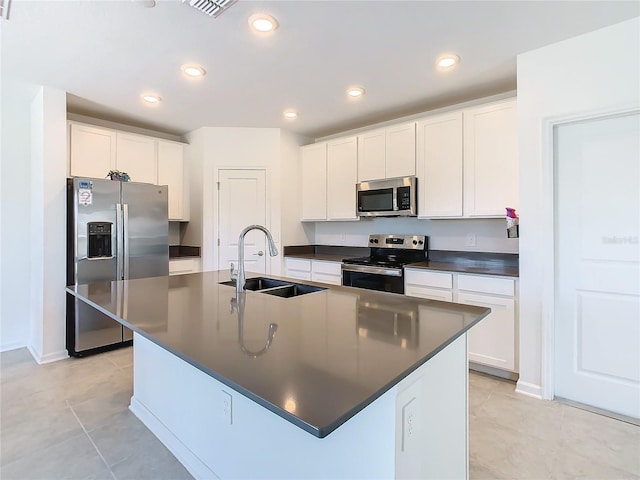 kitchen featuring stainless steel appliances, a sink, dark countertops, white cabinets, and recessed lighting