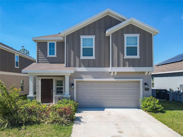 view of front of house featuring board and batten siding, roof with shingles, concrete driveway, an attached garage, and stucco siding