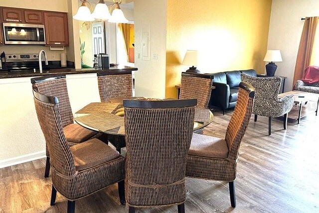 8101 Resort Village Dr Unit 31501, Orlando, FL 32821 - dining room with light wood finished floors, baseboards, and a notable chandelier