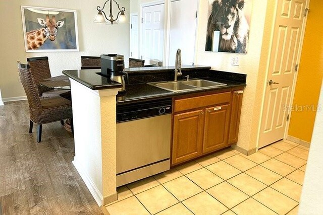 8101 Resort Village Dr Unit 31501, Orlando, FL 32821 - kitchen featuring dark countertops, stainless steel dishwasher, brown cabinets, and a sink
