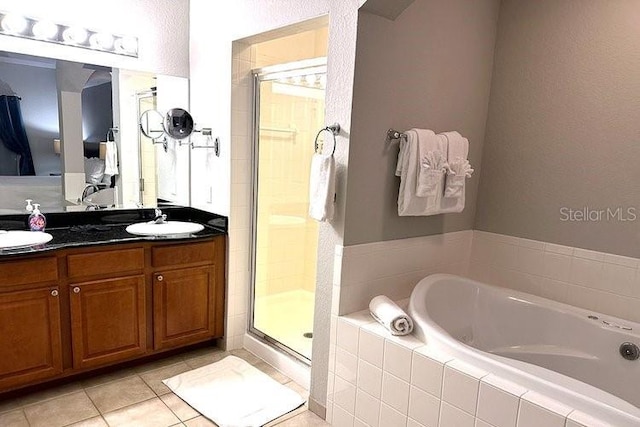 8112 Poinciana Blvd Unit 1502, Orlando, FL 32821 - full bathroom with double vanity, a garden tub, a stall shower, a sink, and tile patterned floors