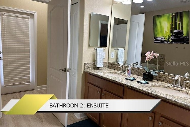 1466 Moon Valley Dr, Champions Gate, FL 33896 - full bath featuring a sink, double vanity, and wood finished floors
