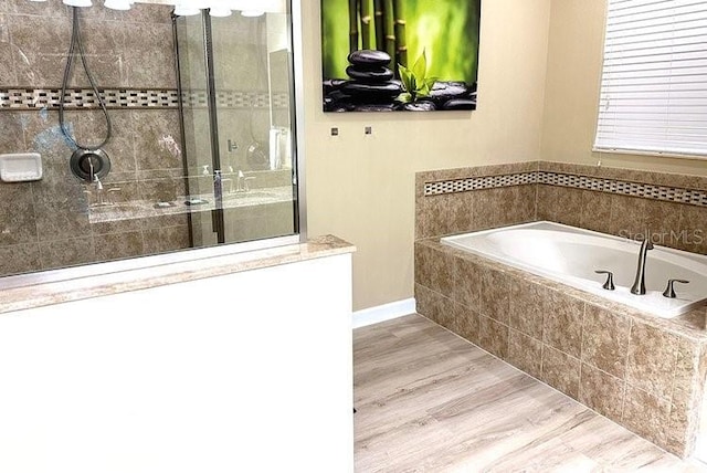 1466 Moon Valley Dr, Champions Gate, FL 33896 - bathroom featuring a garden tub, baseboards, wood finished floors, and a shower stall