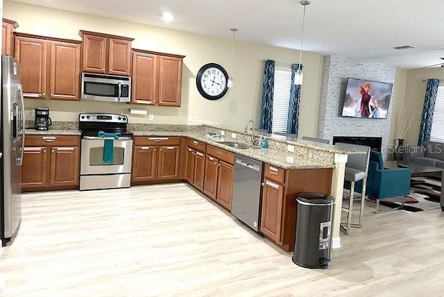 1466 Moon Valley Dr, Champions Gate, FL 33896 - kitchen featuring a sink, a kitchen bar, a peninsula, light wood-style floors, and stainless steel appliances