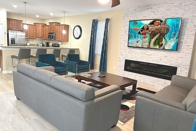 1466 Moon Valley Dr, Champions Gate, FL 33896 - living area featuring light wood-type flooring and a stone fireplace