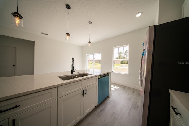 16600 SW 23rd Avenue Rd, Ocala, FL 34473 - kitchen with freestanding refrigerator, dishwasher, a sink, white cabinetry, and light wood-style floors