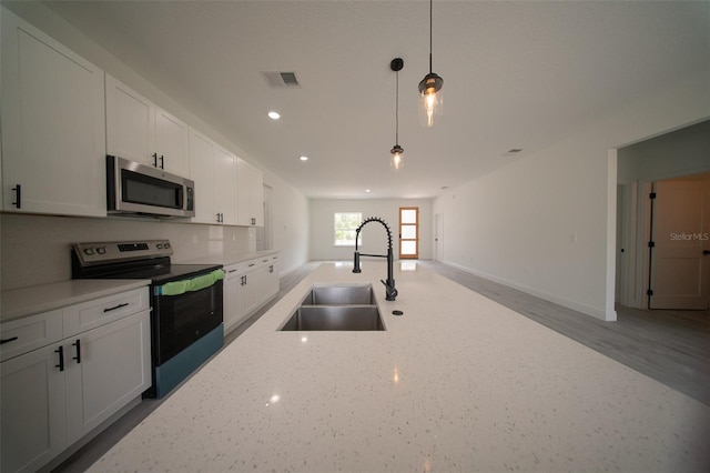 16600 SW 23rd Avenue Rd, Ocala, FL 34473 - kitchen featuring a sink, stainless steel appliances, decorative light fixtures, visible vents, and white cabinets