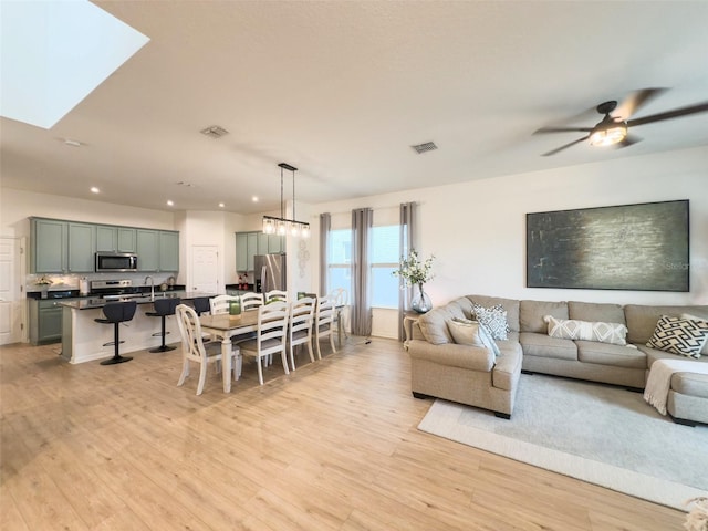 living room featuring light wood finished floors, recessed lighting, and a ceiling fan