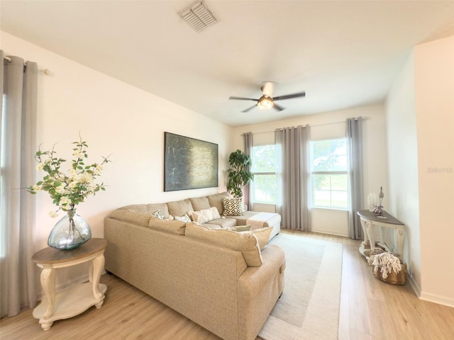 living room with light wood finished floors, ceiling fan, and baseboards