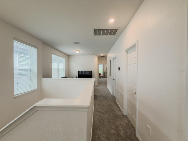 hallway with dark carpet, baseboards, and recessed lighting