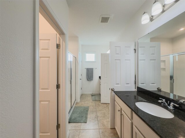 full bath with a stall shower, vanity, and tile patterned flooring