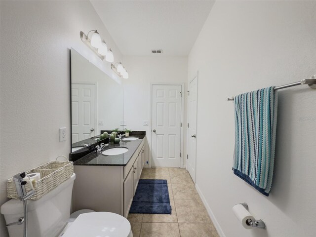bathroom with toilet, tile patterned flooring, and double vanity