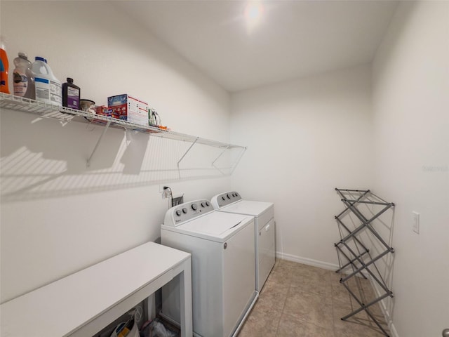 washroom with washer and dryer and baseboards