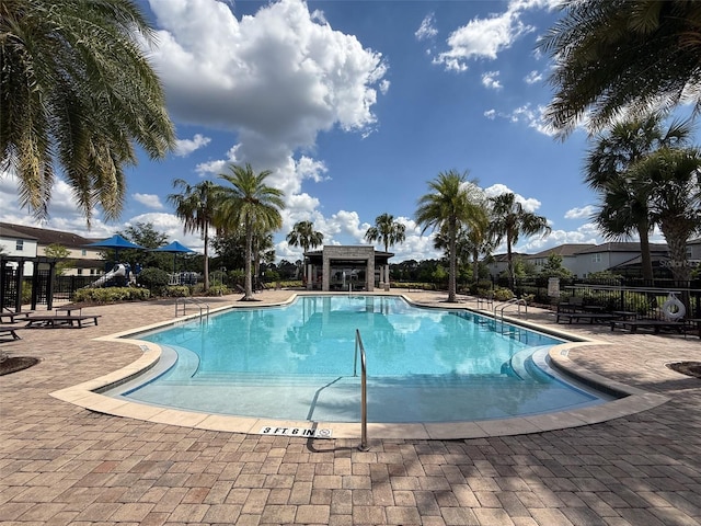 community pool featuring fence and a patio area