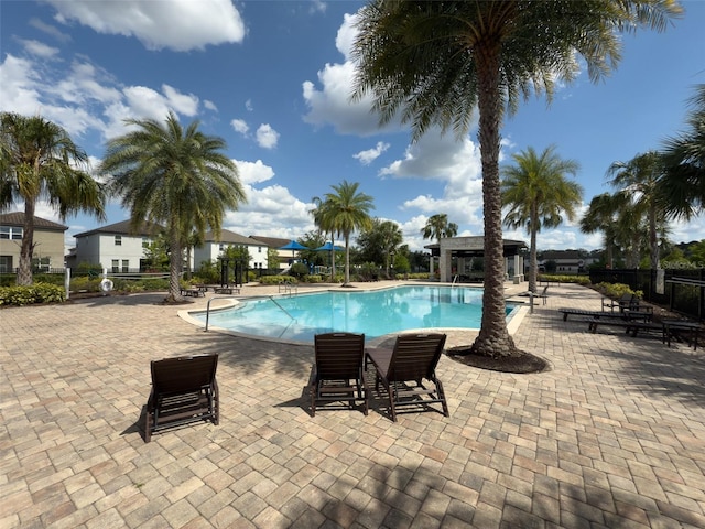 community pool featuring fence and a patio