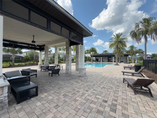 view of patio / terrace featuring fence, a community pool, and a ceiling fan