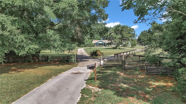 view of property's community with a lawn and asphalt driveway
